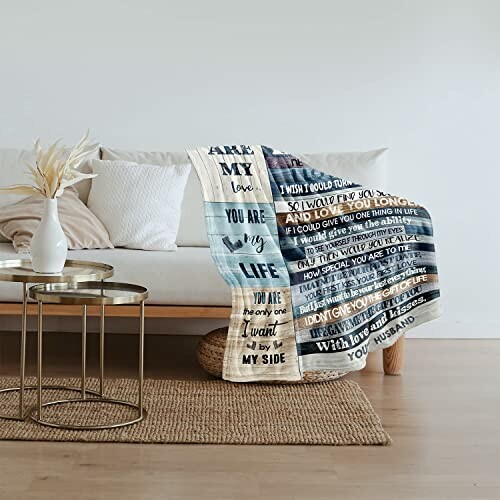 Cozy blanket with love message draped over sofa in living room.