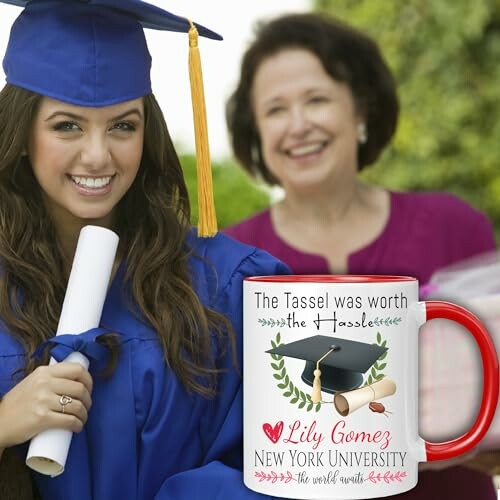 Graduate in blue gown holding diploma with personalized mug.